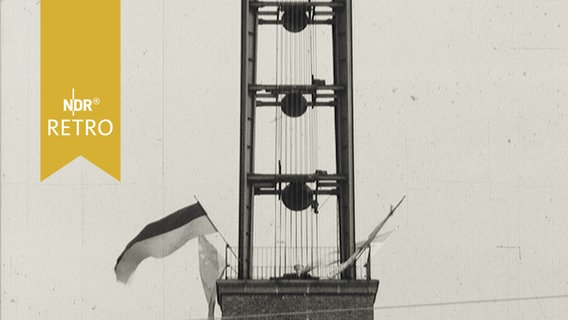 Glockenturm im Grenzdurchgangslager Friedland mit Beflaggung zum 20-jährigen Jubiläum 1965  