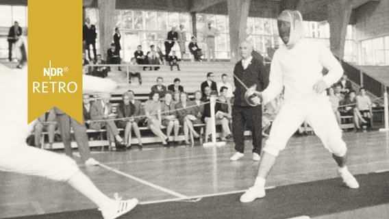 Zwei Fechter beim Turnier "Wappen von Hamburg" 1965 in einer Halle  