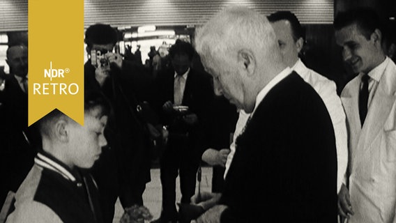 Charlie Chaplin gibt einem Jungen ein Autogramm auf dem Flughafen Hamburg-Fuhlsbüttel (1961)  