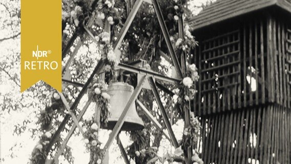Glocke hängt zur Weihe in einem geschmückten Gerüst (1961)  