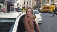 NDR Reporterin Stefanie Gromes lehnt sich an ein Taxi. © NDR / Fabienne Hurst 