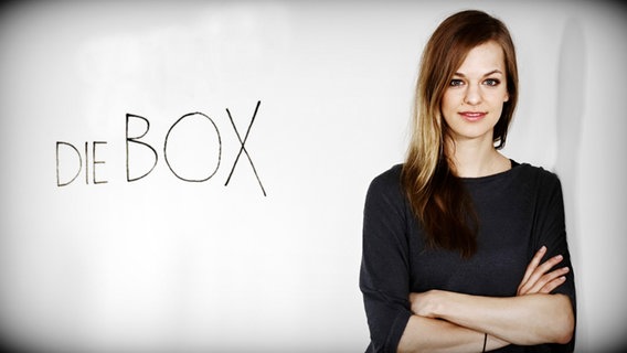 Autorin Caroline Rollinger vor einer Wand mit dem Schriftzug "DIE BOX".  