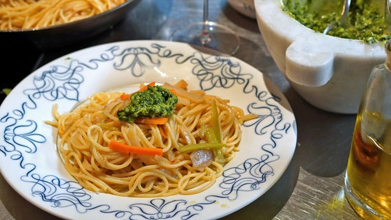 Spaghetti mit Suppengemüse und Pesto auf einem Teller serviert. © NDR Foto: Florian Kruck