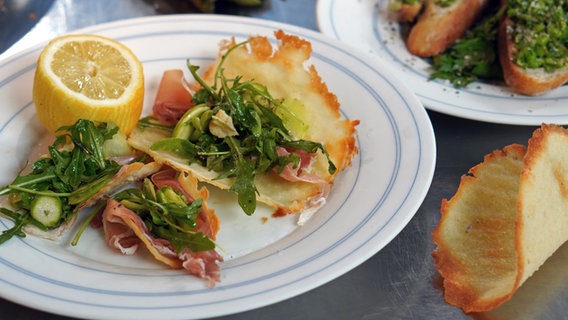 Tacos mit Spargel-Rucola-Salat und Schinken auf einem Teller angerichtet. © NDR Foto: Florian Kruck