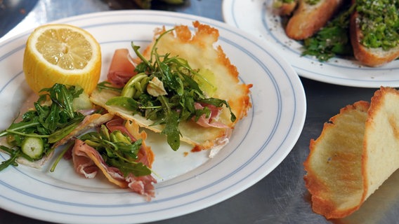 Tacos mit Spargel-Rucola-Salat und Schinken auf einem Teller angerichtet. © NDR Foto: Florian Kruck