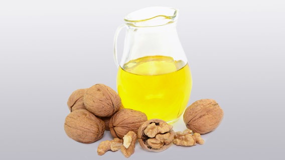 Karaffe mit Walnussöl und Walnüsse auf einem Tisch Karaffe mit Walnussöl und Walnüsse auf einem Tisch © Fotolia.com Foto: photocrew