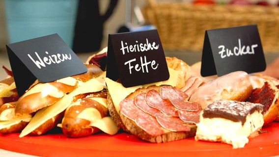 Ungesunde Ernährung: Laugenstangen, Wurstbrote und Kuchen liegen auf einem Teller. Ungesunde Ernährung: Laugenstangen, Wurstbrote und Kuchen liegen auf einem Teller. © NDR