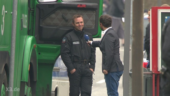 Sportreporter Jakob Leube im Interview mit einem Polizei beim G7-Gipfel der Außenminister in Lübeck 2015.  