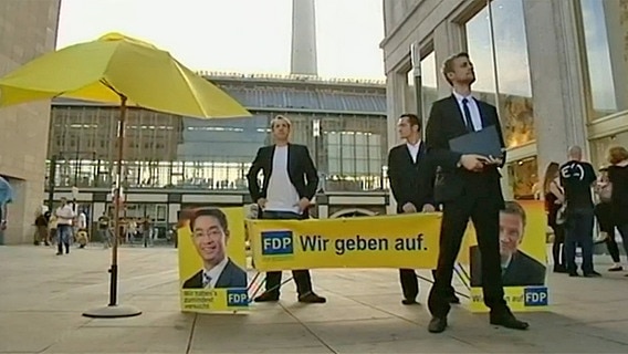 Tobi Schlegl vor einem gefälschtem FDP-Banner  