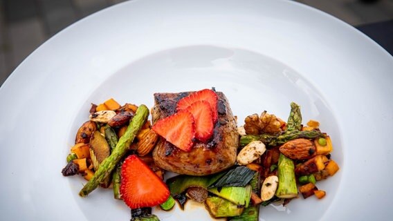 Schweinefilet mit buntem Gemüse und Kimchi auf einem Teller serviert. © NDR Foto: Dave Hänsel