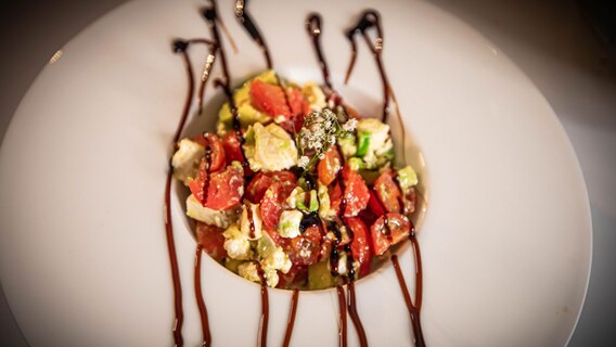 Ein Teller mit Salat aus Tomaten und Schafskäse. © NDR Foto: Dave Hänsel