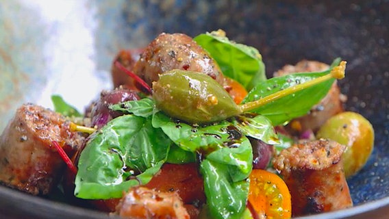 Salciccia-Salat mit Oliven, Tomaten und Kapernäpfeln auf einem Teller © NDR Foto: Tarik Rose