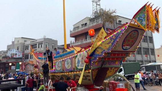 Ein Boot, das nie schwimmen wird: Für die Wang-Ye-Feste bauen die Taiwaner große Holzschiffe, beladen sie mit Opfergaben und ziehen sie Richtung Meer. Dort werden sie aber nicht zu Wasser gelassen, sondern angezündet. Ein Boot, das nie schwimmen wird: Für die Wang-Ye-Feste bauen die Taiwaner große Holzschiffe, beladen sie mit Opfergaben und ziehen sie Richtung Meer. Dort werden sie aber nicht zu Wasser gelassen, sondern angezündet. © NDR/Julian Ringer