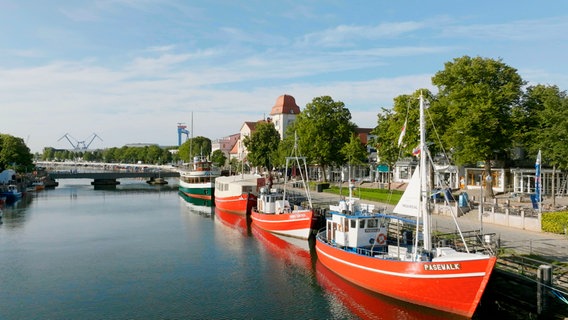 "Am Strom" heißt die beliebte Warnemünder Flaniermeile mit ihren Fischkuttern – "Strom" meint den Fluss Warnow, der hier in die Ostsee mündet. "Am Strom" heißt die beliebte Warnemünder Flaniermeile mit ihren Fischkuttern – "Strom" meint den Fluss Warnow, der hier in die Ostsee mündet. © NDR/Eddy Zimmermann/Sebastian Lindemann