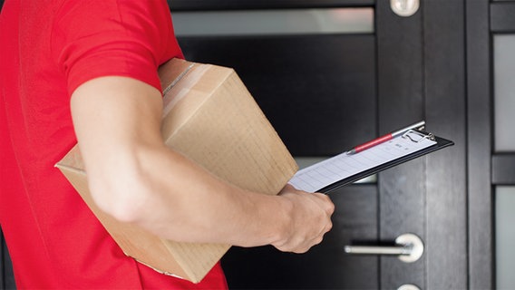 Paketbote an einer Haustür. © fotolia Foto: Photographee.eu