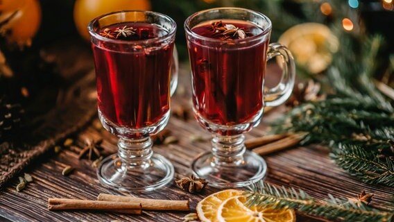 Zwei Gläser mit rotem Glühwein stehen in weihnachtlicher Kulisse. © Colourbox Foto: Aleksandr Korchagin