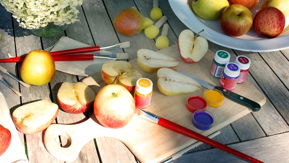 Äpfel, Birnen und Farben und Pinsel liegen auf einem Tisch. © NDR Foto: Isabell Hayn