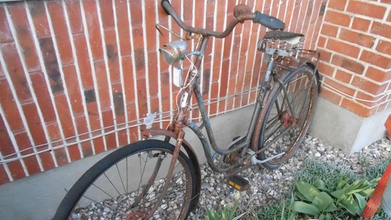 Ein altes, verrostetes Fahrrad lehnt an einer Hauswand. © NDR/Martin Hopp 