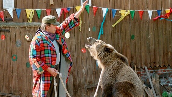 Szenenbild aus der 1. Büttenwarder-Folge "Der Bär" steppt: Brakelmann (Jan Fedder) dressiert einen Bären. © NDR/Videoscope 