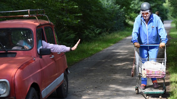 Szenenbild aus der 66. Büttenwarder-Folge "Rekord": Jürgen Seute und Onkel Krischan mit Einkaufswagen auf einem Feldweg. © NDR/Nicolas Maack Foto: Nicolas Maack