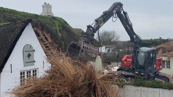 Ein Bagger zerstört das Reetdach des Alten Gasthofs auf Sylt. © NDR 