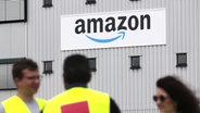 Menschen stehen vor einem Firmenschild von Amazon © NDR 