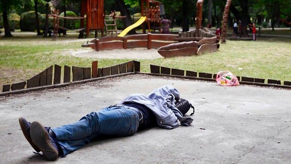 Ein syrischer Flüchtling schläft auf einem Spielplatz im Park einer serbischen Stadt in der der Nähe der ungarischen Grenze. © dpa/picture-alliance 