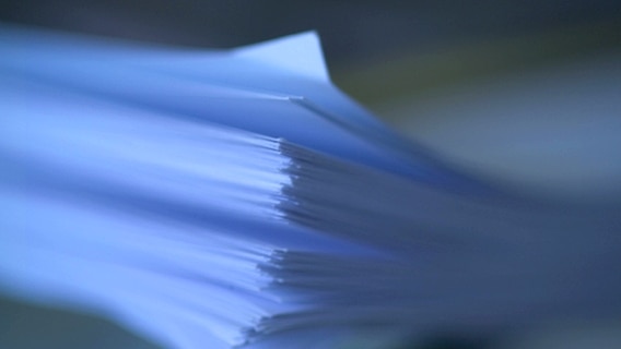 Ein unscharf aufgenommener Stapel Papier. © Imago Foto: McPHOTO