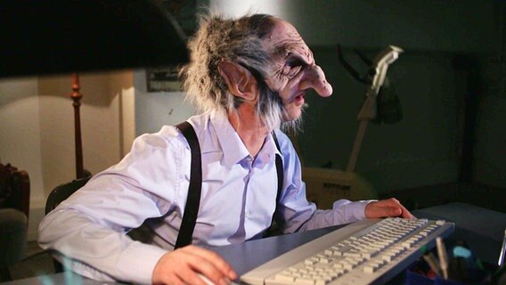 Ein Mann mit einer Trollmaske sitzt am Computer © NDR 