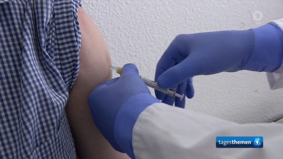 Ein Proband bekommt eine Spritze mit einem möglichen Corona-Impfstoff in den Oberarm.  