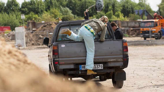 Jessi (Martha Fries) klettert von hinten auf die Ladefläche eines Pick Ups. © NDR Foto: Claudia Timmann