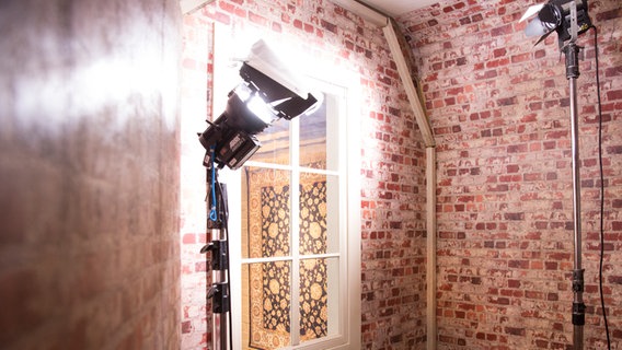 Ein Scheinwerfer leuchtet gegen die Decke eines Raumes mit Backsteinwänden. © NDR Foto: Claudia Timmann