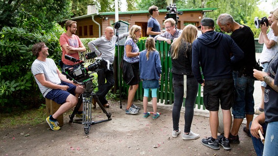 Das Filmteam steht vor einem Gartentor. © NDR Foto: Claudia Timmann