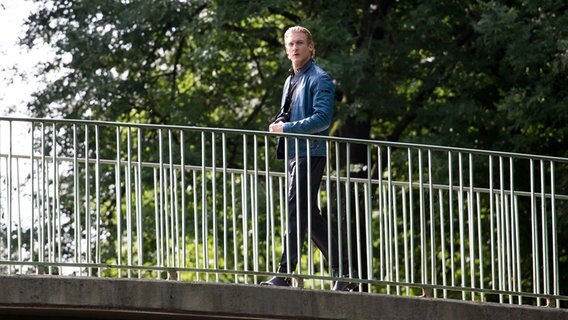 Boris Leskow (Martin Walde) geht auf einer Brücke. © NDR Foto: Claudia Timmann