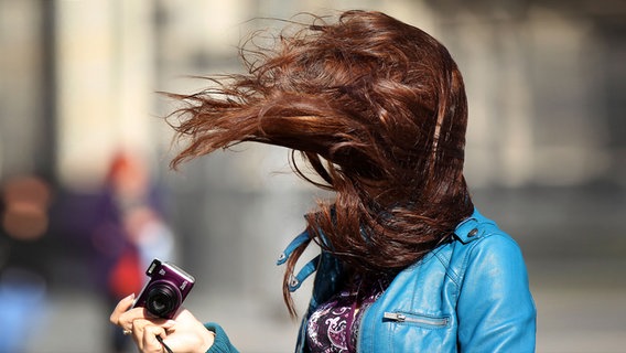 Windböen wehen einer Frau die Haare ins Gesicht. © picture alliance/dpa Foto: obe pzi
