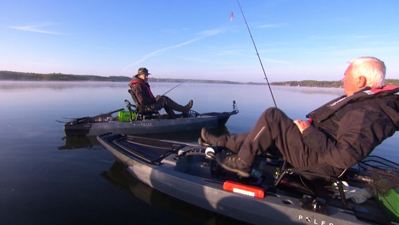 Kajakangeln auf dem Güstrower Inselsee. Moderator Heinz Galling (links) ist mit dem NDR Angelexperten Horst Hennings den Hechten auf der Spur. © NDR 