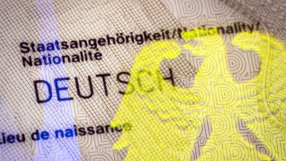 Auf einem Personalausweis spiegelt sich neben dem Schriftzug Staatsangehörigkeit Deutsch ein Bundesadler als Hologramm. © imago Foto: photothek