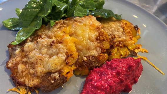 Smashed Potatoes mit Rote Bete Dip und Spinatsalat auf einem Teller angerichtet. © NDR 