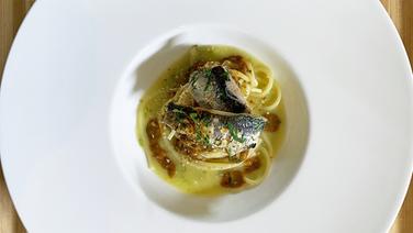 Spaghetti mit marinierten Sardellen und Zitronensoße auf einem weißen Teller angerichtet. © NDR 