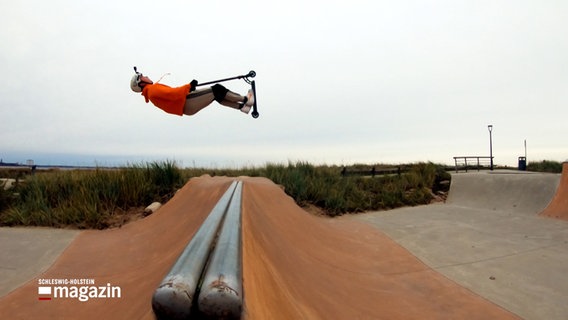 Ein Stunt-Scooter-Fahrer springt auf einer Rampe im Skate-Park in Scharbeutz. © NDR 