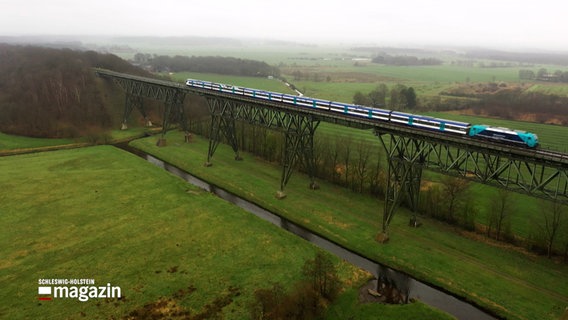 Ein Zug rollt über die Hochdonn-Eisenbahnbrücke. © NDR 