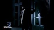 In einer nachgestellten Szene sieht man wie eine Person nachts in ein Haus einzubrechen. © NDR Foto: NDR Screenshots