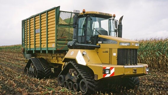 Ein gelbe Erntemaschine auf Raupen auf einem Maisfeld. © NDR/Volker Schult 