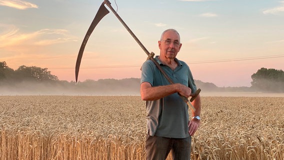 Mit der Sense hat Wilhelm Lüdeke seinen Vater noch auf ihren Getreidefeldern in Wietzen im Landkreis Nienburg arbeiten sehen. Sein Vater hat die schwere Arbeit damals mit seiner Kamera gefilmt. © NDR/Katrin Heineking 