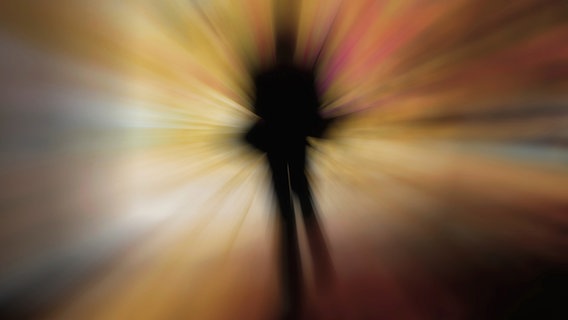 Unscharfe Silhouette einer Person in buntem Lichtnebel © Fotolia.com Foto: HeikoKueverlin