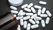 Weiße Tabletten liegen auf einem dunklen Untergrund © colourbox Foto: kostsov