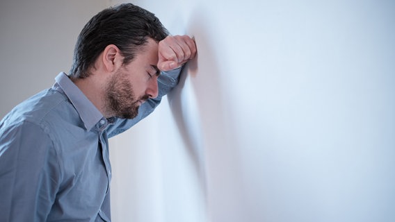 Ein Mann lehnt seinen Kopf an eine Wand. © fotolia.com Foto: Paolese