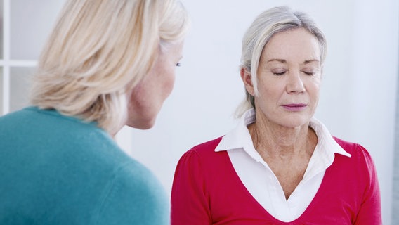 Eine ältere Frau konzentriert sich, mit geschlossenen Augen auf die Worte einer Therapeutin. © fotolia.com Foto: RFBSIP