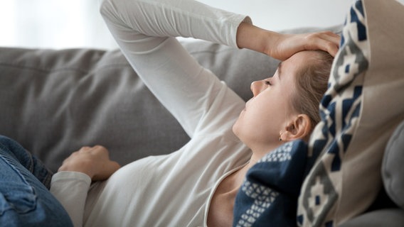 Ein Frau liegt müde auf einem Sofa. © Colourbox Foto: Aleksandr