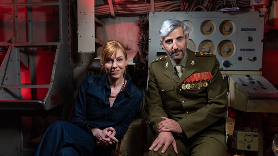Eva Schulz und Michel Abdollahi (von links nach rechts) sitzen nebeneinander in einem U-Boot. © Telemichel GmbH 